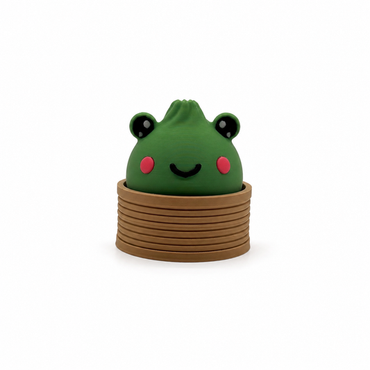 Wasabi the Frog clicker, a 3D printed frog dumpling fidget clicker sitting in a steam basket